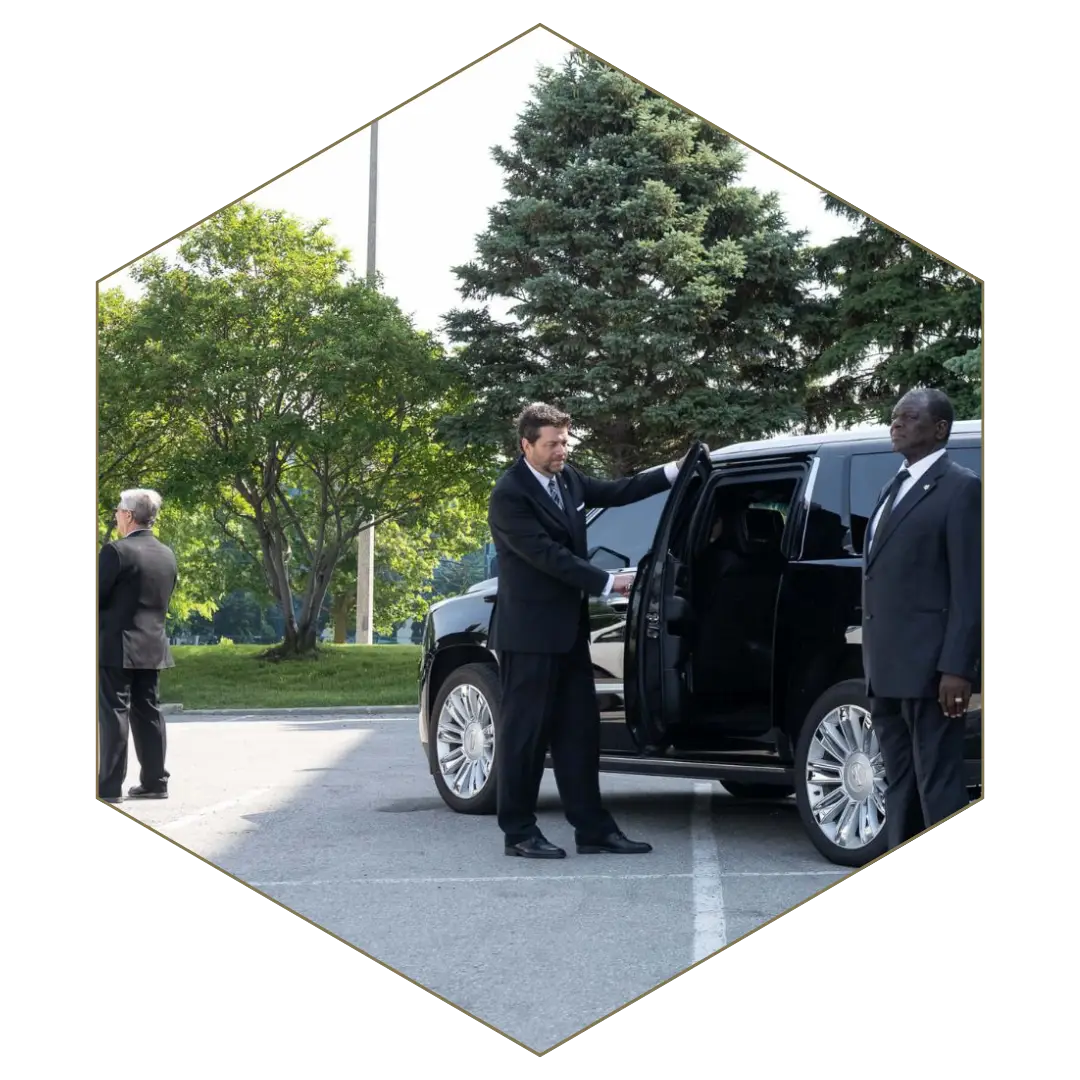 Executive protection bodyguard assisting client into black SUV for secure transportation.