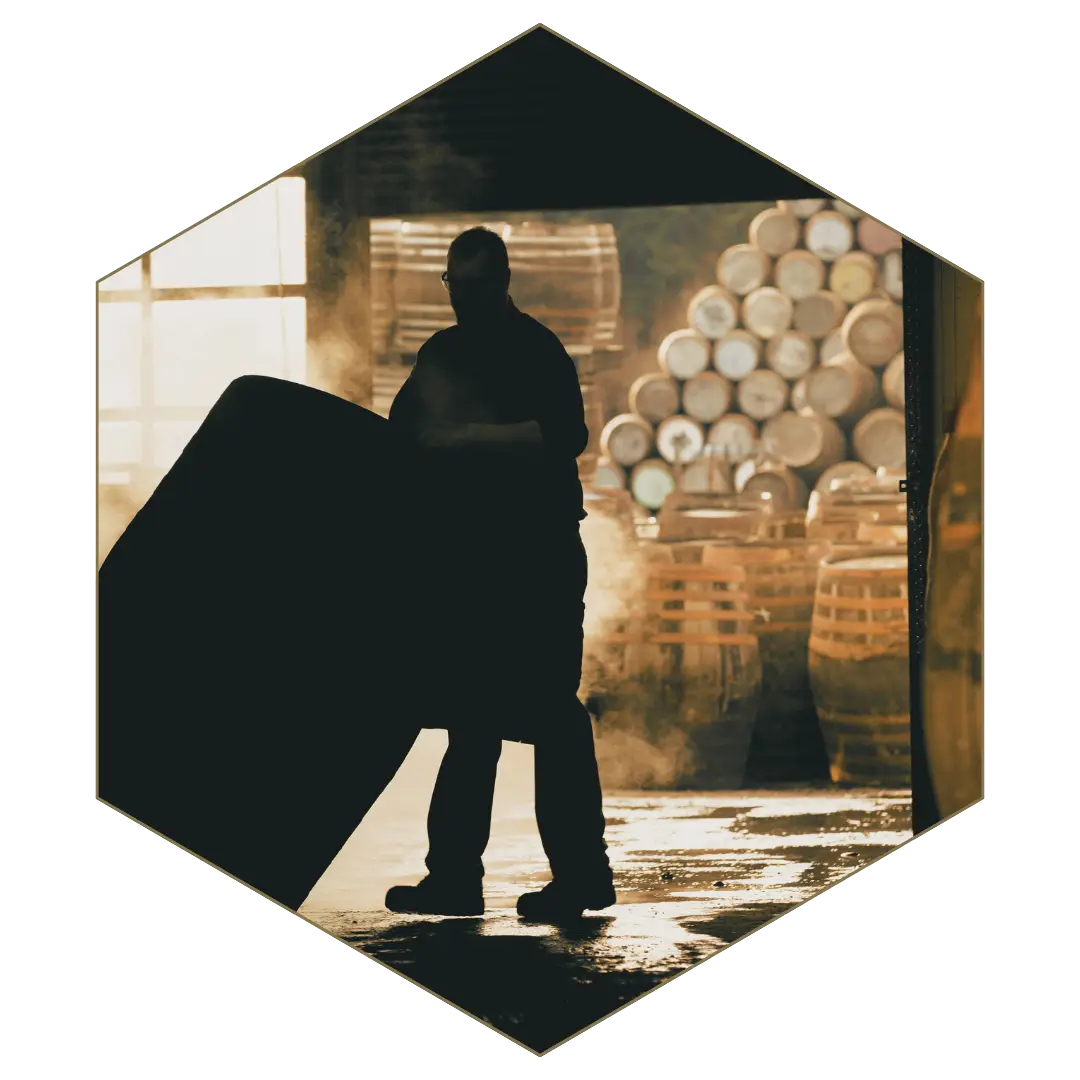 Supply chain investigation — worker inspecting stacked barrels in warehouse storage facility.